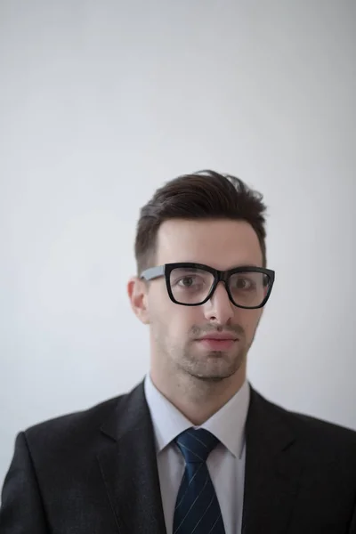 Portrait d'un jeune homme d'affaires de mode avec des lunettes nerd sur gris — Photo