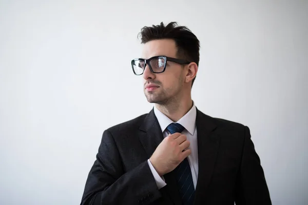 Beyaz bir arka plan kravatını ayarlama bir iş adamı portresi. — Stok fotoğraf