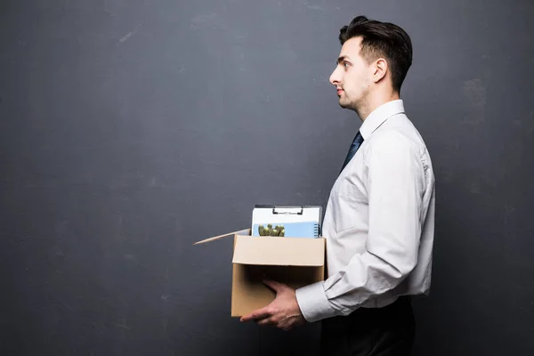 Homem de negócios demitido transportando caixa. Isolado em cinza — Fotografia de Stock