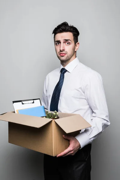 Getting fired. Handsome young businessman in suit in office with the box with his stuff — Stock Photo, Image