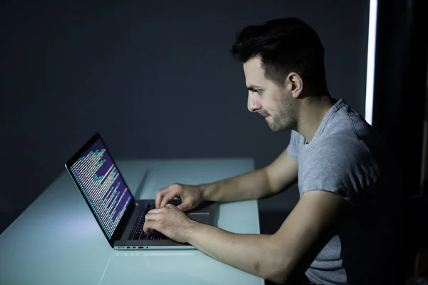 Компьютерный хакер работает в темной комнате программирования ночью — стоковое фото