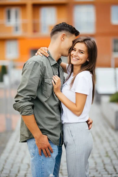Jolie été ensoleillé portrait en plein air de jeune couple tout en s'embrassant dans la rue . — Photo