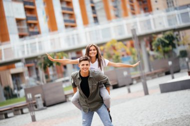 Güzel yaz anlar. neşeli genç kadın sevgilisi arkasında otururken kollarını germe