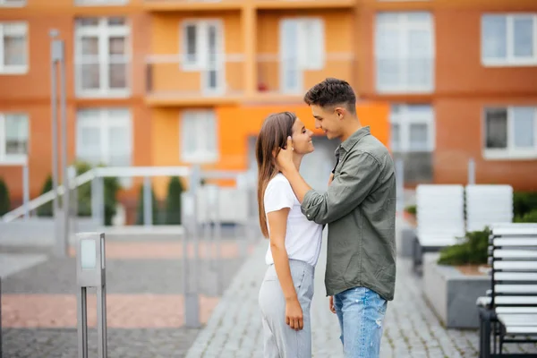 Мужчина и женщина гуляют по городу. Мужчина и женщина целуются на городской улице . — стоковое фото