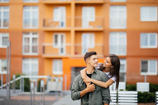 Joven hombre dando girlfirend paseo a caballo en la calle de la ciudad —  Fotos de Stock