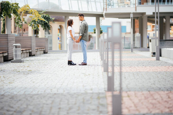Happy couple in the street looking each other falling in love summer