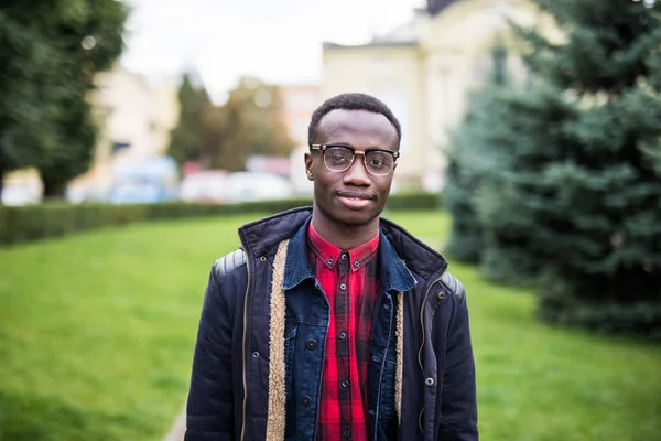 Современный студент колледжа с кожаной сумкой, афроамериканец, стоящий у стены на улице — стоковое фото