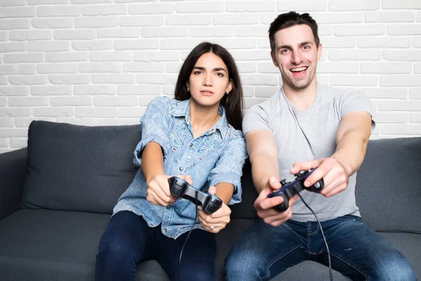 Νεαρό ζευγάρι αναπαραγωγή βίντεο παιχνίδια στο σπίτι στο σπίτι — Φωτογραφία Αρχείου