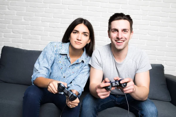 Hermosa pareja jugando videojuegos en la consola divirtiéndose en casa —  Fotos de Stock