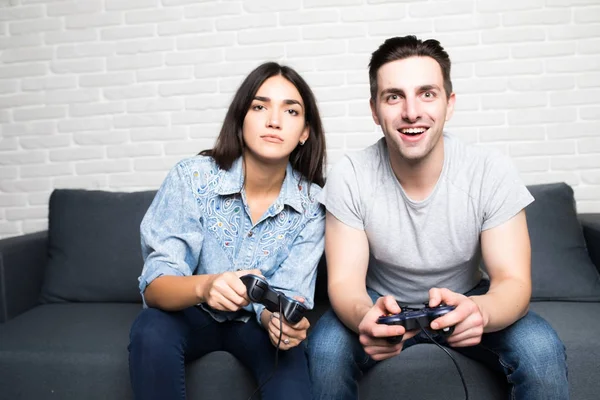 Νεαρό ζευγάρι παίζοντας βιντεοπαιχνίδια με διασκέδαση στο σπίτι — Φωτογραφία Αρχείου