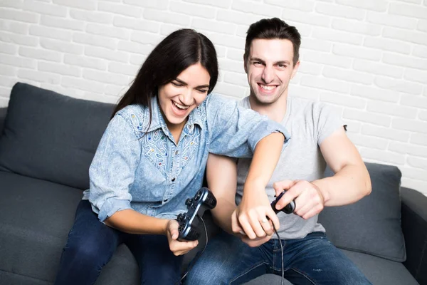 Νεαρό ζευγάρι παίζοντας βιντεοπαιχνίδια με διασκέδαση στο σπίτι — Φωτογραφία Αρχείου
