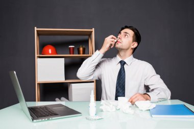 Hasta bir adam ofiste onun işyerinde oturuyor. O kendini burun çalışma ofisinde bir tıbbi sprey boğazına spreyler