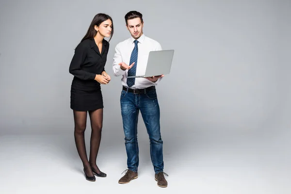 Hermosa joven mujer de negocios y hombre de negocios guapo en trajes formales están utilizando una computadora portátil . — Foto de Stock