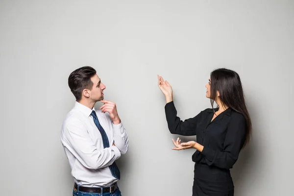 Mujer de negocios sonriente y hombre de negocios están conversando sobre fondo gris . — Foto de Stock