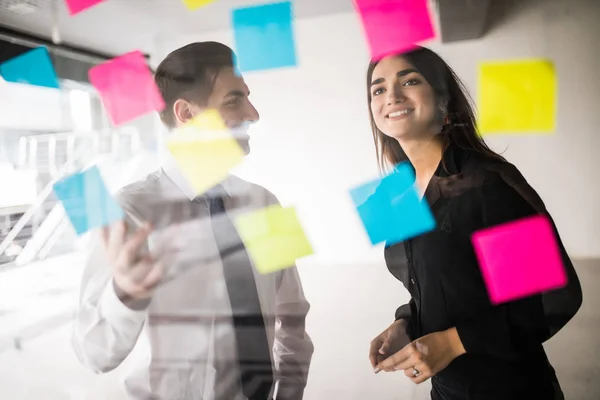 Business, opstarten, planning, beheer en mensen concept - gelukkig creatieve team schrijven op stickers bij office glas board — Stockfoto