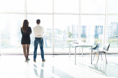 Ofis personeli bir şey onların sırt ile pencere durarak tartışıyor. Takım çalışması.