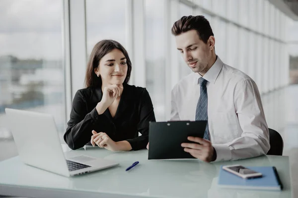 Klienten signerar ett dokument i ett kontor med en affärskvinna som ser kontraktet. Kontorsarbete — Stockfoto