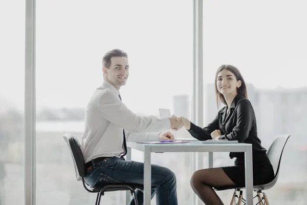 Amistoso hombre de negocios sonriente y mujer de negocios apretón de manos sobre el escritorio de la oficina después de una charla agradable y una negociación efectiva, buenas relaciones. Foto concepto de negocio — Foto de Stock