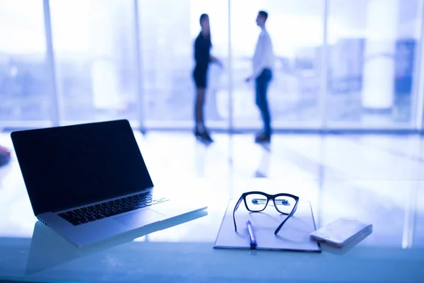 Close up van bril op Bureau met grafiek en laptop op zakelijke werkplek met mensen uit het bedrijfsleven bijeen achtergrond. — Stockfoto