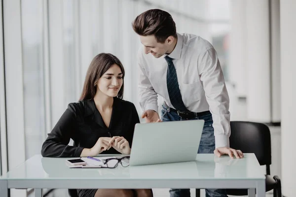 Affärsmannen och affärskvinna arbetar med laptop på moderna kontor. Man diskutera med kvinna planer. — Stockfoto