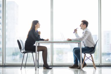 Businessman And Businesswoman Meeting In Modern Office face to face discuss plans clipart