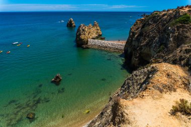 Loule, Portekiz - Haziran, 2017. Praia, kayalar ve kayalıklarla Algarve, Portekiz arasında kumlu plaj güzel deniz manzaralı. Güneşli açık havada arka plan