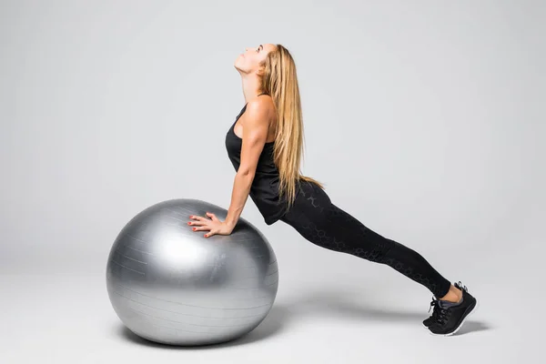 Jovem mulher esportiva com bola de ginástica em um fundo branco . — Fotografia de Stock