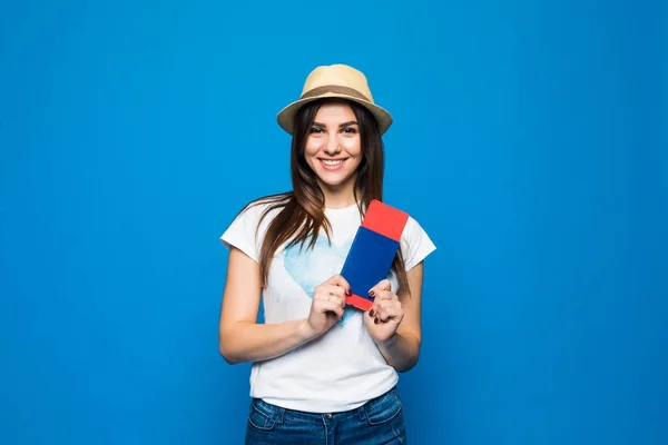 Nő utas a jegy útlevéllel. Mosolygós boldog lány készen áll a kék háttér utazási portréja — Stock Fotó