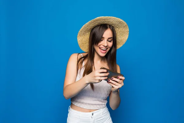 Woman play game on her cell phone isolated over blue background