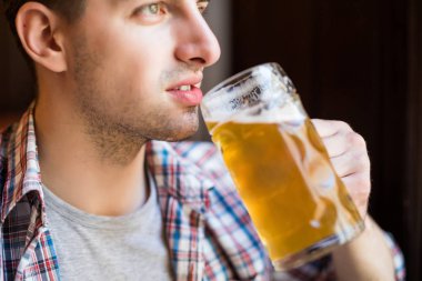Taze demlendi bira tadımı. Yakışıklı genç erkek brewer metal konteynerler önünde duran süre taze bira tadımı önlük