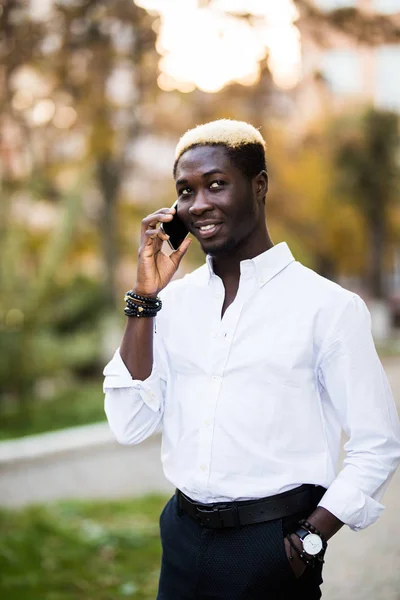 Amerikaans Afrikaans man met mobiele in de straat. Communicatieconcept. — Stockfoto