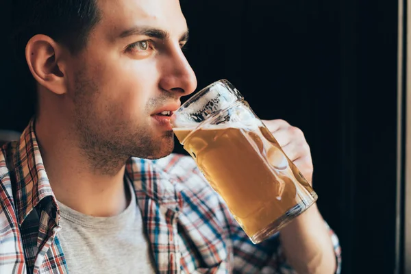 Close up de jovem bebendo cerveja de vidro em bar ou pub — Fotografia de Stock