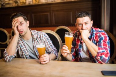 Genç adam üzgün bakan sakallı ve üzgün bira sahip pub boşaltmak depresyon stres sorunları sorunları içme yorgun yorgun kriz mutsuz hayal kırıklığı pişman üzüntü yalnızlık alkol