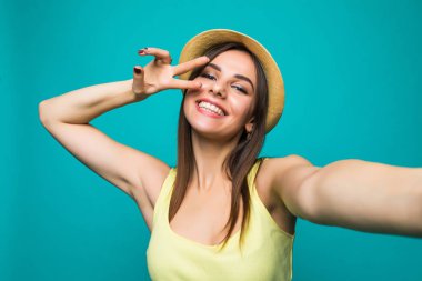 Young woman taking a selfie on a color background