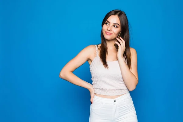 Happy beautiful woman standing in blue wall background and using mobile cell phone calling for friend chatting on freedom time. — Stock Photo, Image