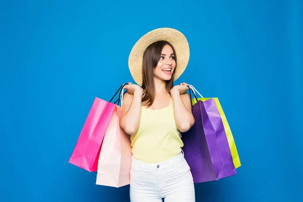 ショッピング バッグにカラフルな青い背景に麦わら帽子を身に着けているファッション ポートレート若い笑顔女性 — ストック写真