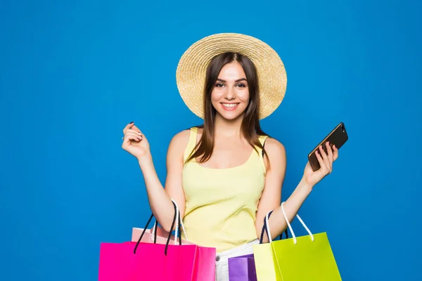 快乐的女人使用手机在一个蓝色背景下的购物销售 — 图库照片