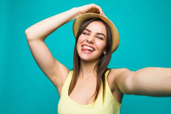 Ritratto di una donna carina sorridente che fa selfie foto facce fanno su smartphone isolato su uno sfondo di colore — Foto Stock