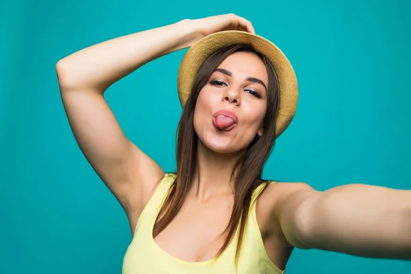 Giovane donna che prende un selfie mostra la lingua su uno sfondo di colore — Foto Stock