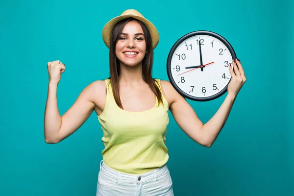 若い緑の背景に幸せな勝利の感情にほぼ 9 を示す時計を保持している女性を興奮してください。 — ストック写真