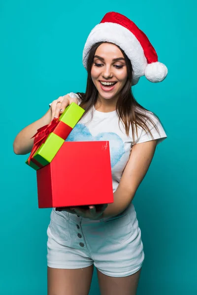 Mooie glimlach vrouw met KERSTMUTS is open geschenk geïsoleerd op een achtergrond met kleur. — Stockfoto