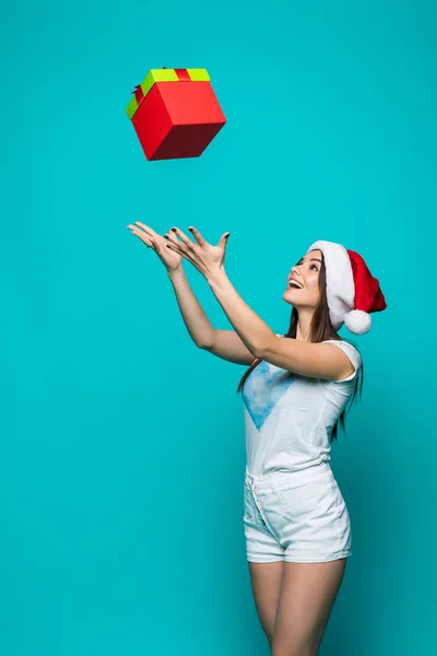 Noel hediyesi renk arka plan üzerinde izole elleri ile Noel Baba şapkası güzellik güzel kadın yakalar — Stok fotoğraf