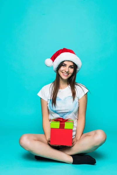 Portret van een gelukkig lachend meisje in jurk houden huidige vak zittend op de vloer geïsoleerd op groene achtergrond — Stockfoto