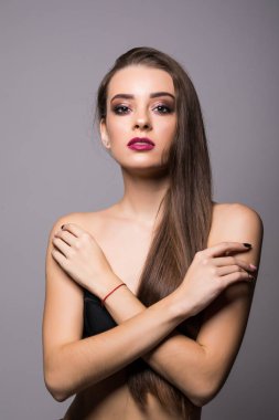 Doğal makyaj, temiz cilt ve gri arka plan üzerinde beyaz dişler ile gülümseyen kız