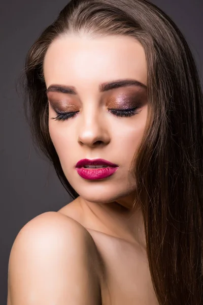 Mooie vrouw met professionele make-up op donkere achtergrond — Stockfoto