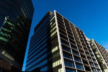 Uzun boylu binanın cam pencere kasaba ışığında yansıtır. Skycrappers modern bina modern gözlüklü