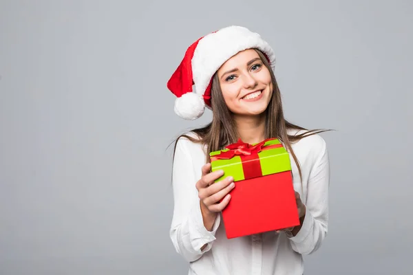 Heureuse jeune femme excitée dans santa claus chapeau avec boîte cadeau sur fond gris — Photo