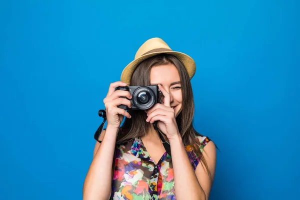 Close up of woman in hat on blue background taking a photo with digital camera — Stock Photo, Image