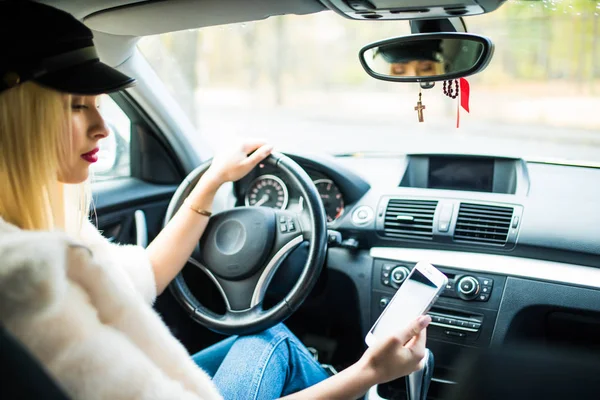 Jovem mulher de beleza motorista usando smartphone tela sensível ao toque e navegação GPS em um carro . — Fotografia de Stock