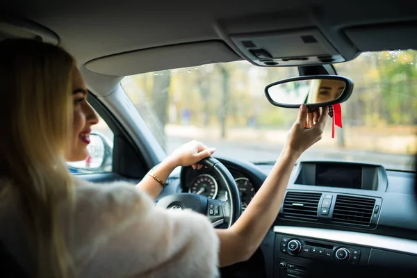 Conducteur heureuse jeune femme regardant réglage rétroviseur de voiture, s'assurer que la ligne est libre visibilité est bonne avant de faire demi-tour. Bon voyage, concept de conduite de voyage — Photo